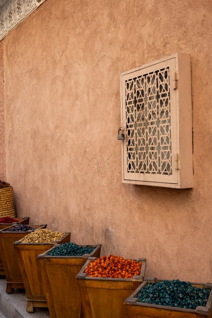Vibrant dried flowers in wooden containers against a decorative wall create an urban art scene.